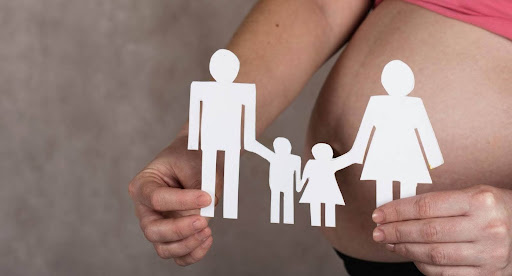 a surrogate holding a paper cutout of a family