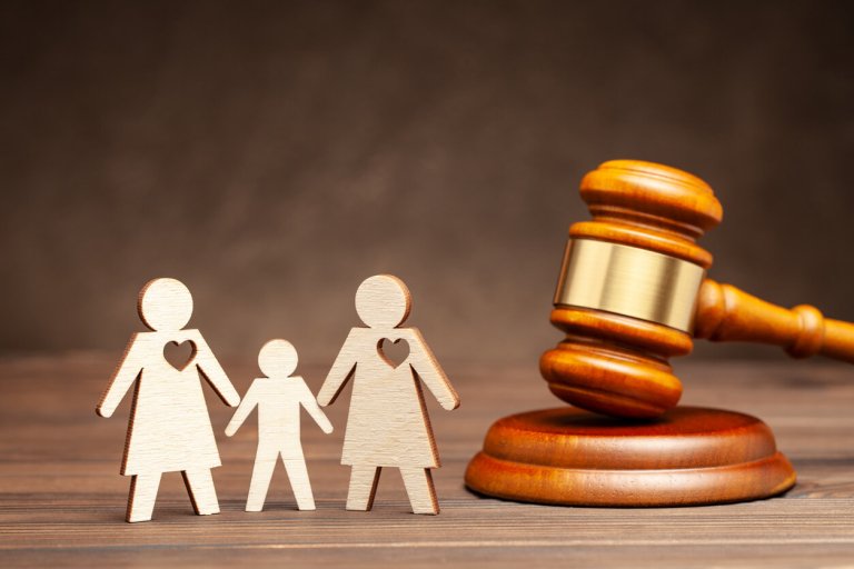 a silhouette of a surrogate family by a gavel representing surrogacy legality