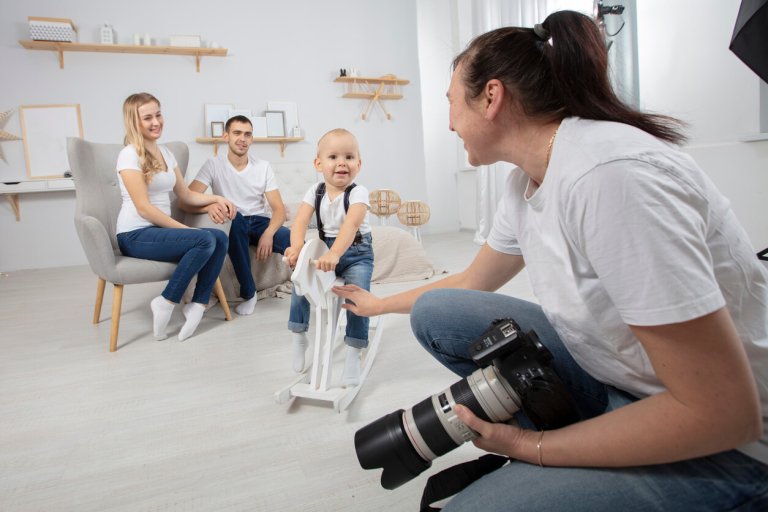 a photographer taking family portraits of intended parents with surrogate babies
